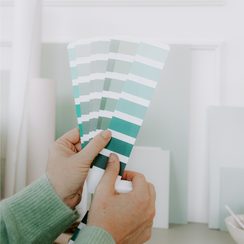 blue paint colour chips and paint colour samples in woman's hand