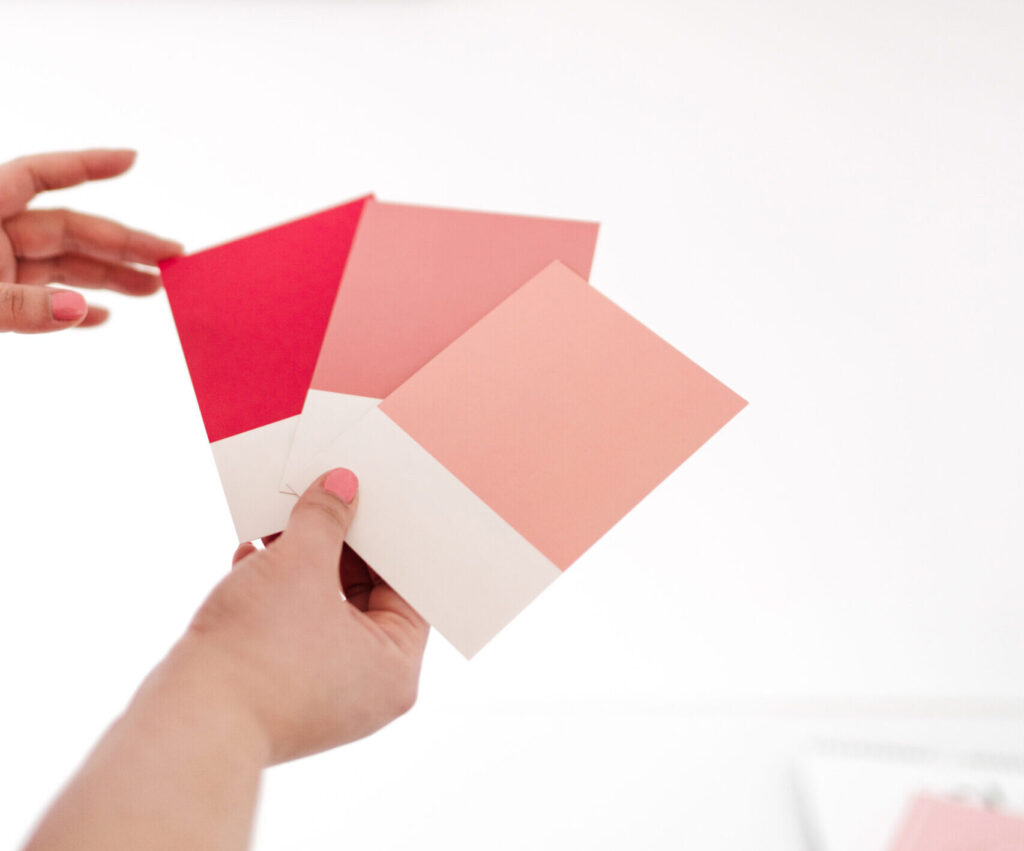 person holding pink paint chips