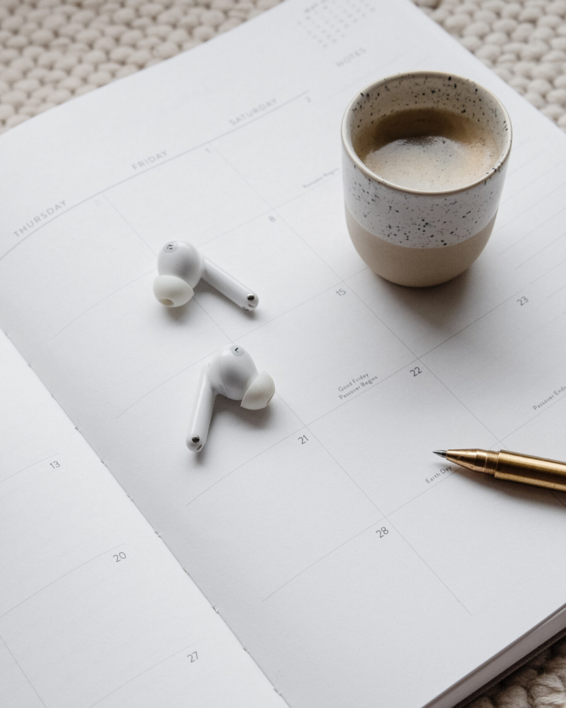 headphones and coffee sitting on planner book